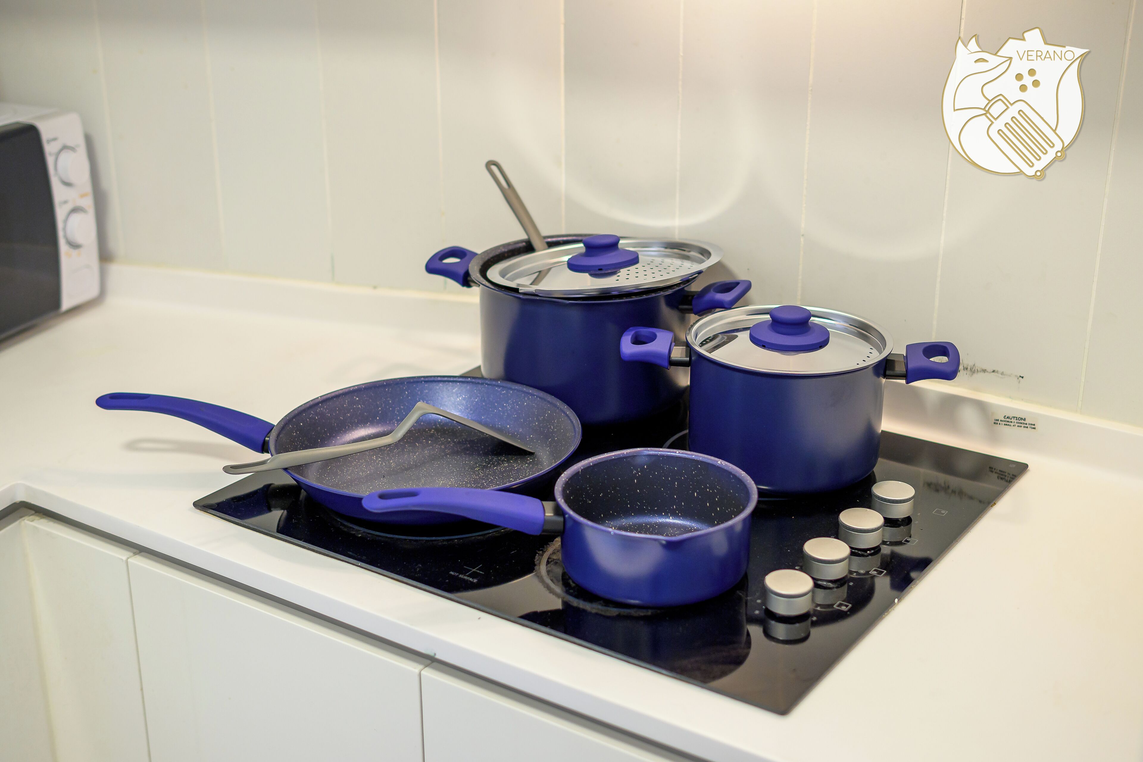 A kitchen with a stove, pots, and pans.
