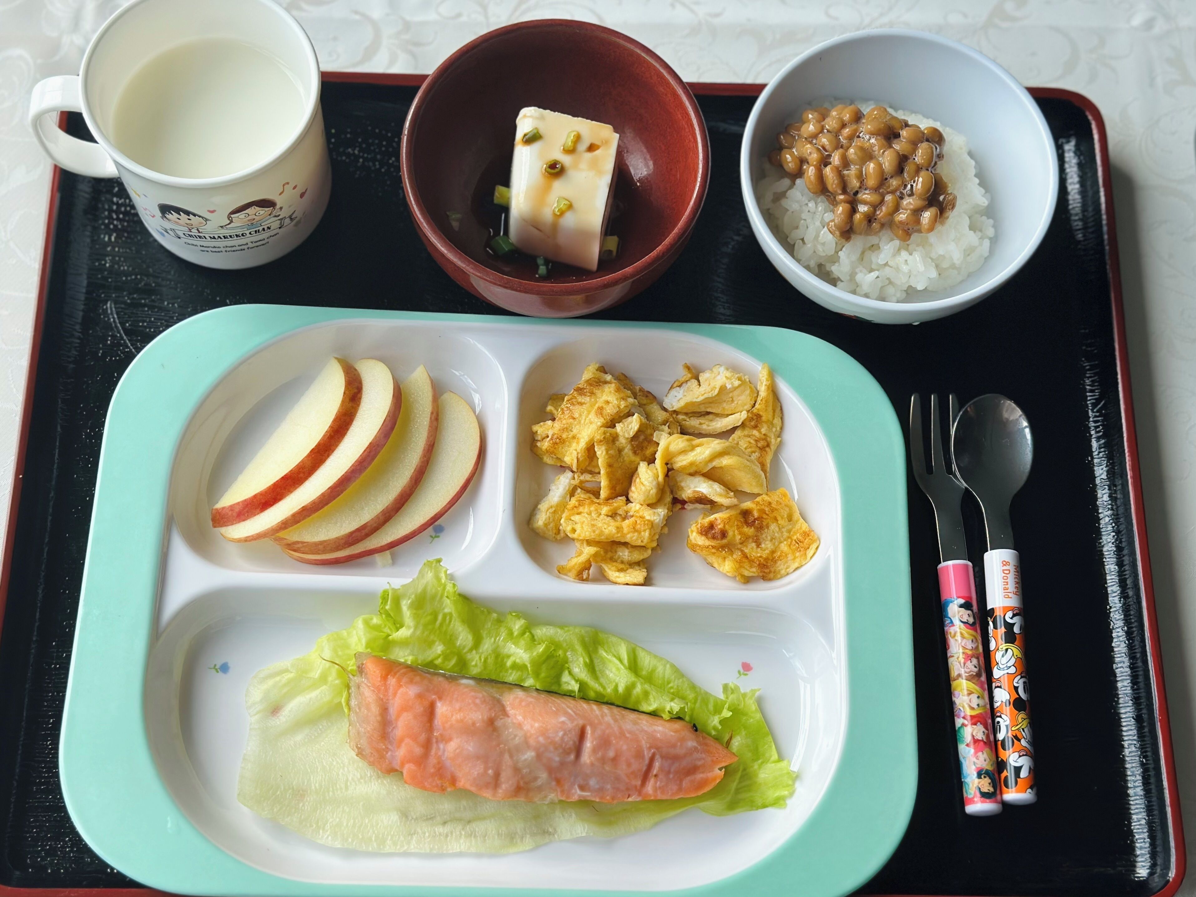Bandeja de comida con una variedad de alimentos, incluyendo arroz, frijoles, tofu, huevos y verduras.