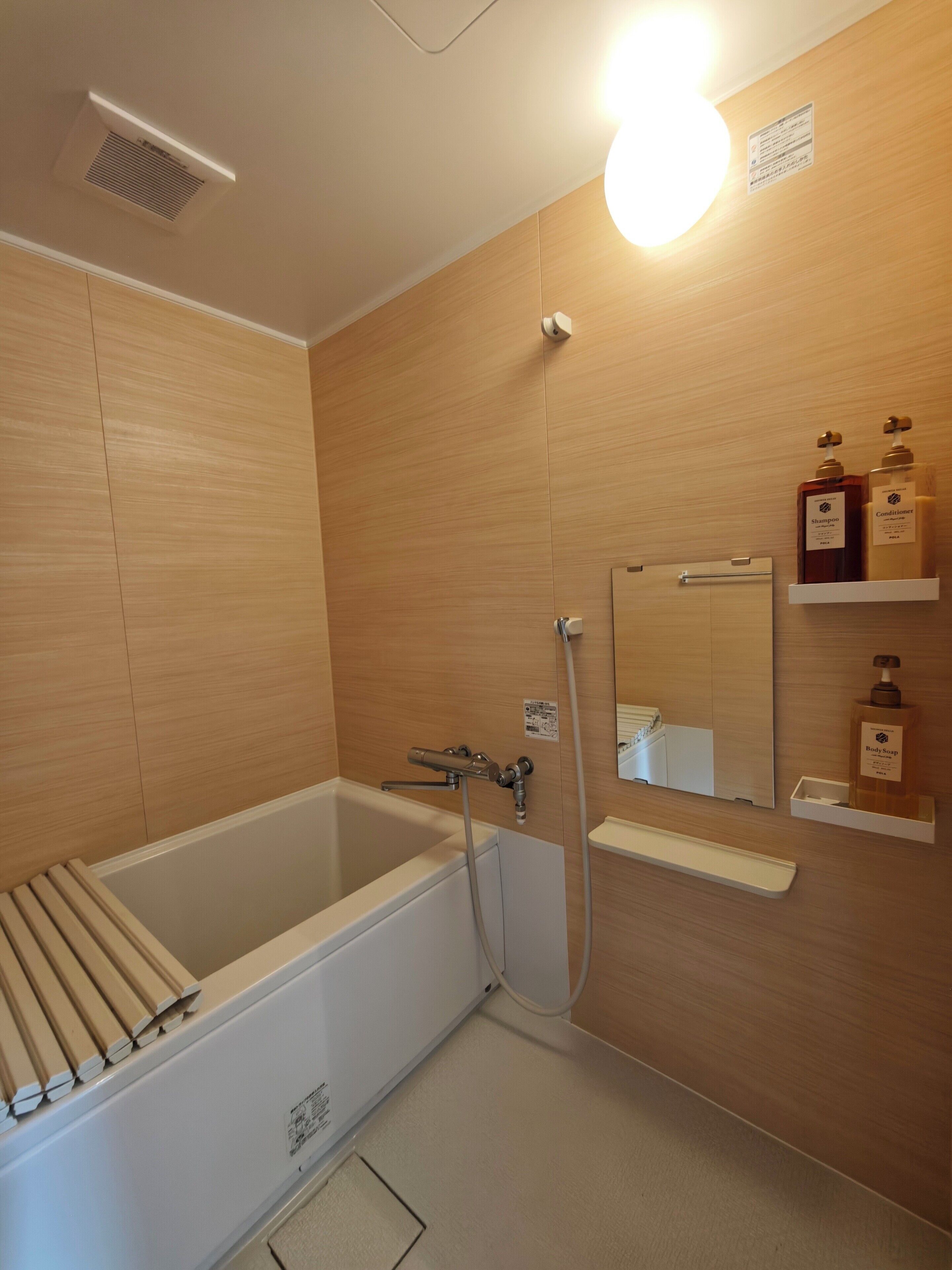 Uma casa de banho moderna com banheira, chuveiro e toucador com produtos de higiene pessoal.