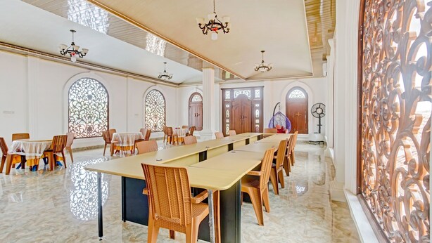 A spacious conference room with a long table, chairs, and decorative lighting. - OYO 90585 Saka Ganta Guest House Syariah (Terbanggi Ilir)