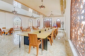 Un'ampia sala conferenze con un lungo tavolo, sedie e illuminazione decorativa.