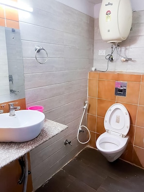 A bathroom with a white sink, a toilet, and a mirror.