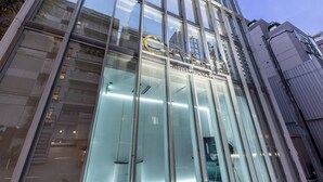 A hotel with a modern glass facade and a prominent sign. - CUVEE J2 HOTEL OSAKA by Onko Chishin (Osaka)