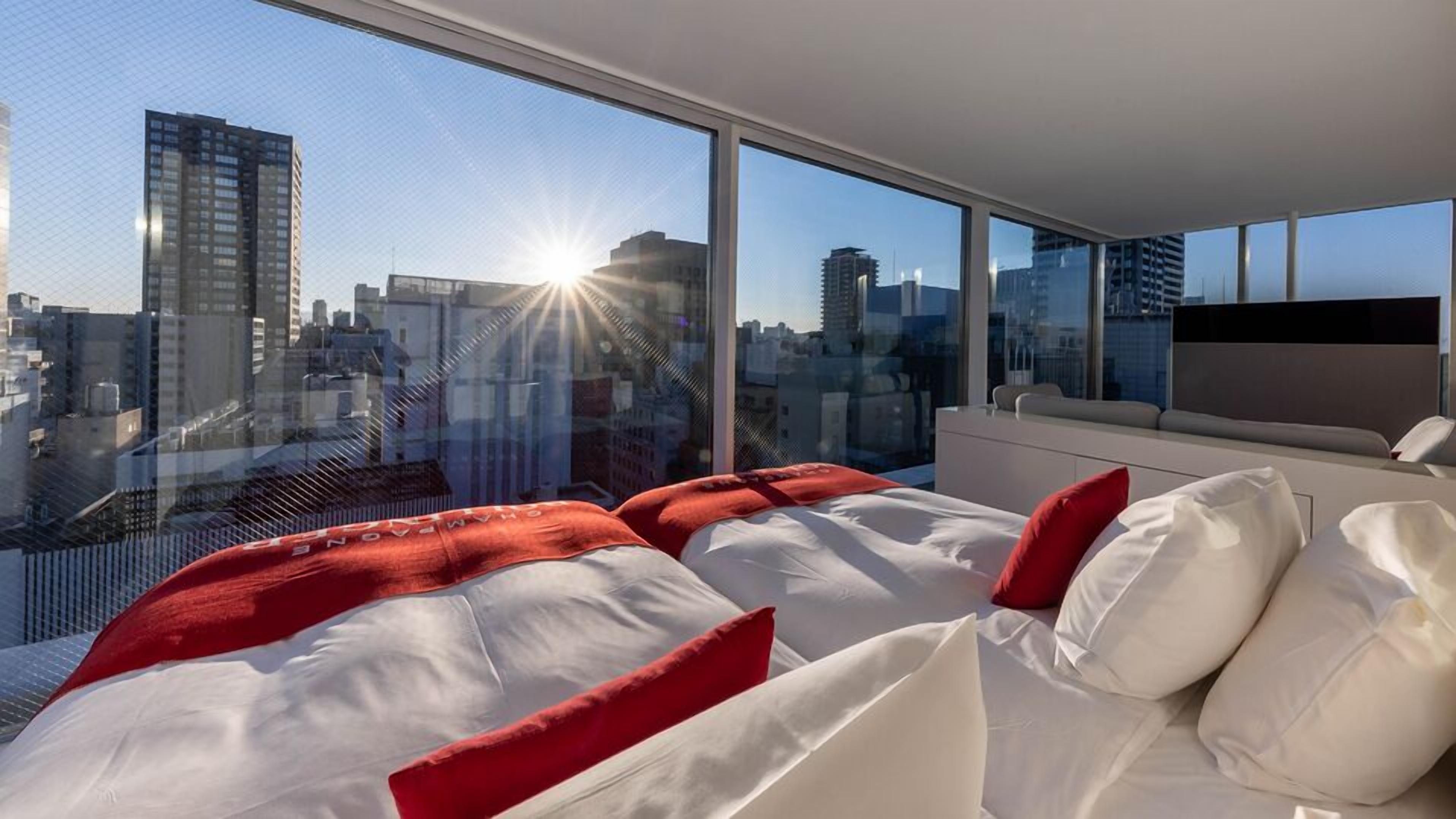 Une chambre d’hôtel moderne avec un grand lit, un canapé et une télévision.
