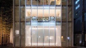 A modern hotel entrance with a glass facade and a sign reading "Hotel Kuvee".