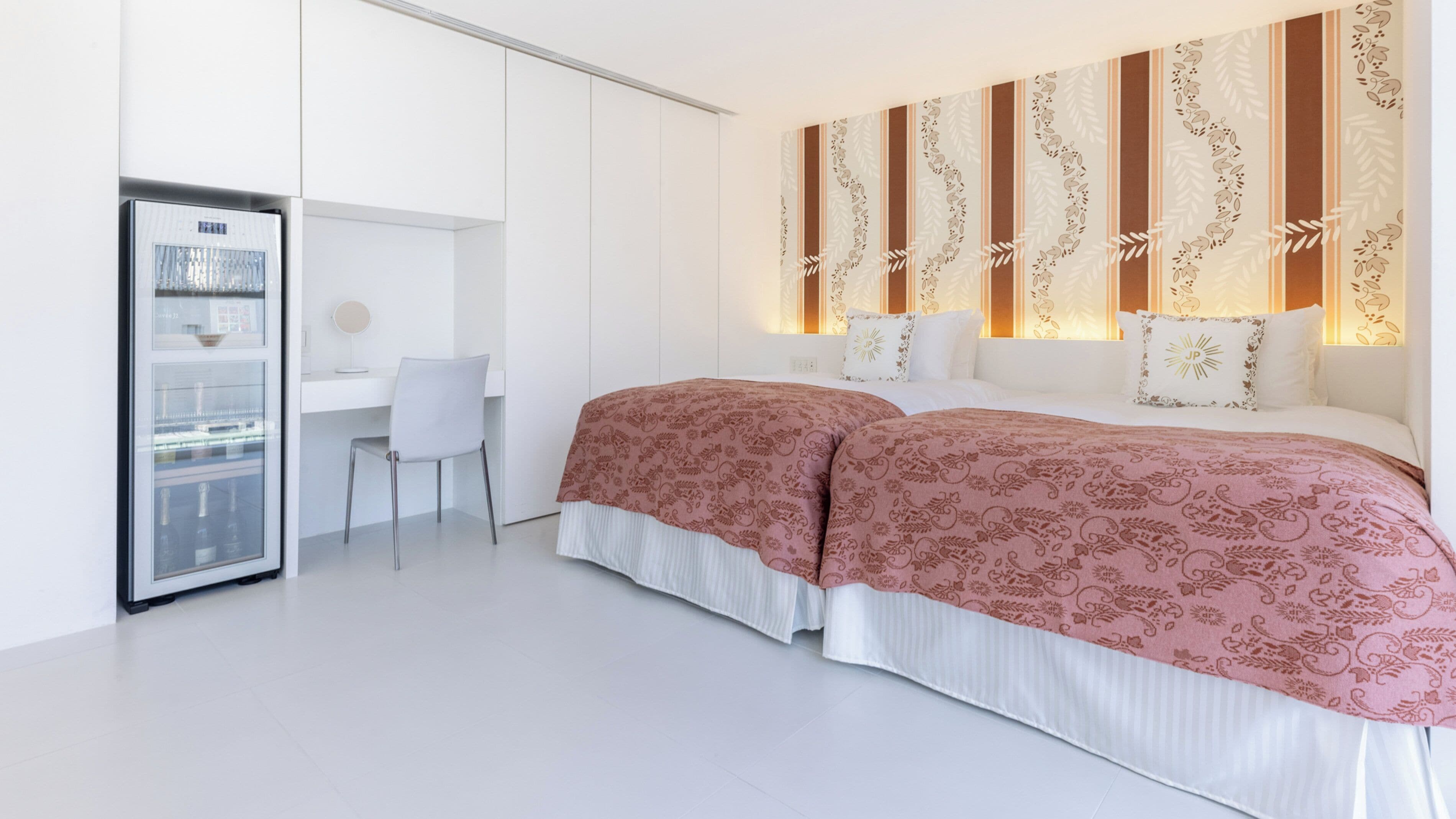 Una camera d'albergo moderna con un letto, una scrivania e un frigorifero.