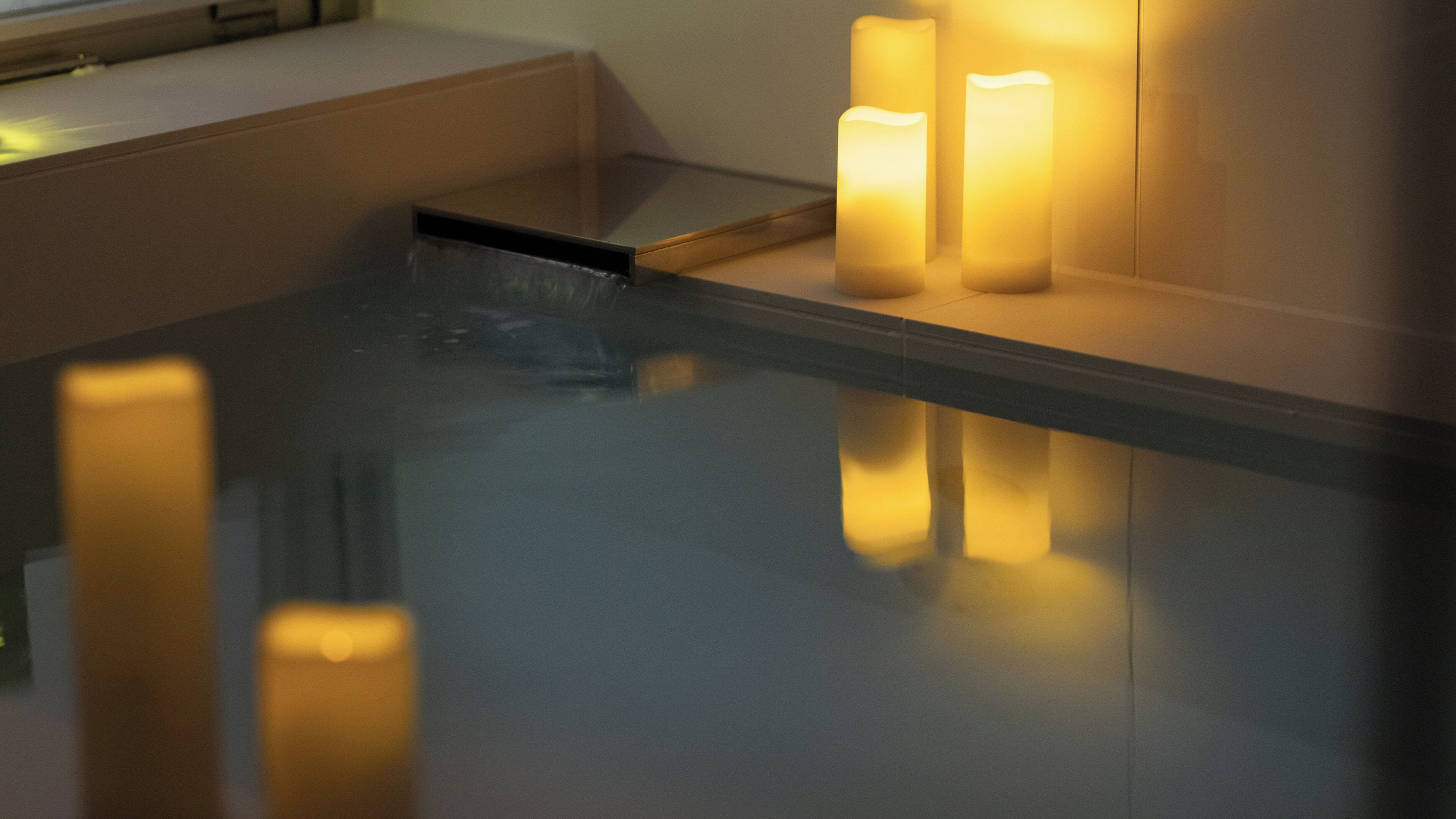 A reflective surface with candles and a tray.