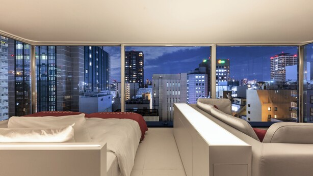 A modern hotel room with a large window offering a city view at night. - CUVEE J2 HOTEL OSAKA by Onko Chishin (Osaka)