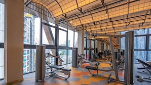 A gym with various exercise equipment, large windows, and a high ceiling. - High Floor KL View Scarletz Suite (Kuala Lumpur)