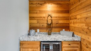 A kitchen with wooden walls, a granite countertop, and a built-in refrigerator. - Cowlitz Manor House in Packwood (Packwood)
