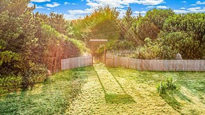 A garden with a wooden pergola, a wooden fence, and various shrubs. - Brathouse By The Sea (Copalis Beach)