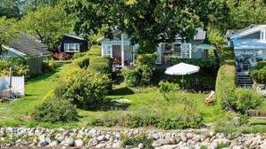 A residential area with houses, a grassy yard, and a rocky shoreline. - "Snari" - 10m from the sea by Interhome (Svendborg)