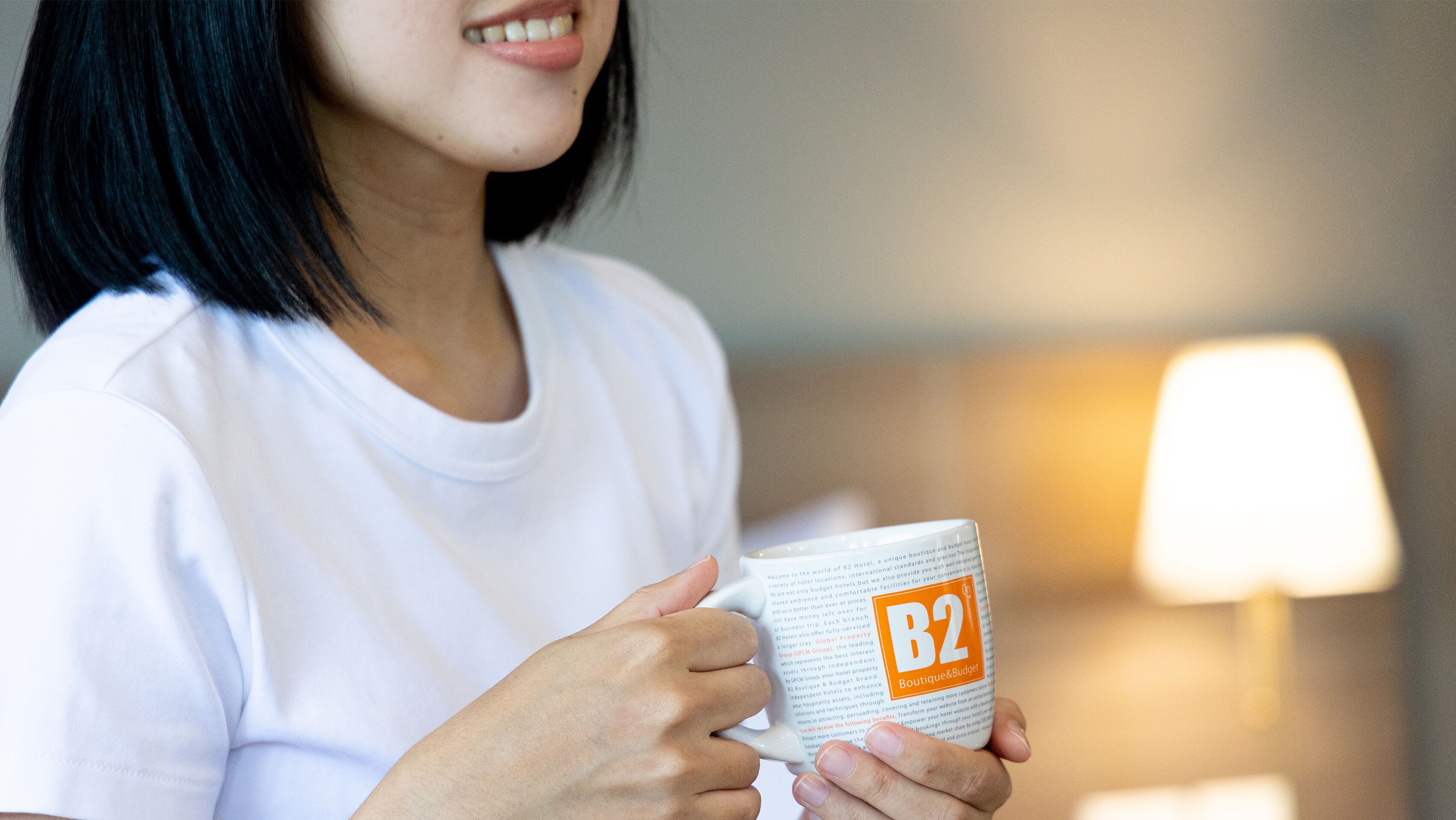 Una persona sosteniendo una taza con un logotipo.