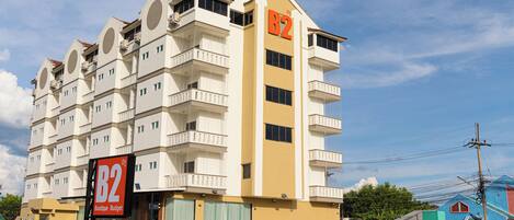 A multi-story hotel with balconies, a prominent 'B2' sign, and a 'Boutique Budget' sign.