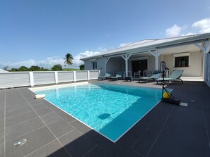 A swimming pool with a white fence, lounge chairs, and a covered area with a view of the sky. - Magnificent Villa "Ti Kaz An Nou" - private pool - 3 min from the beach (Sainte-Rose)