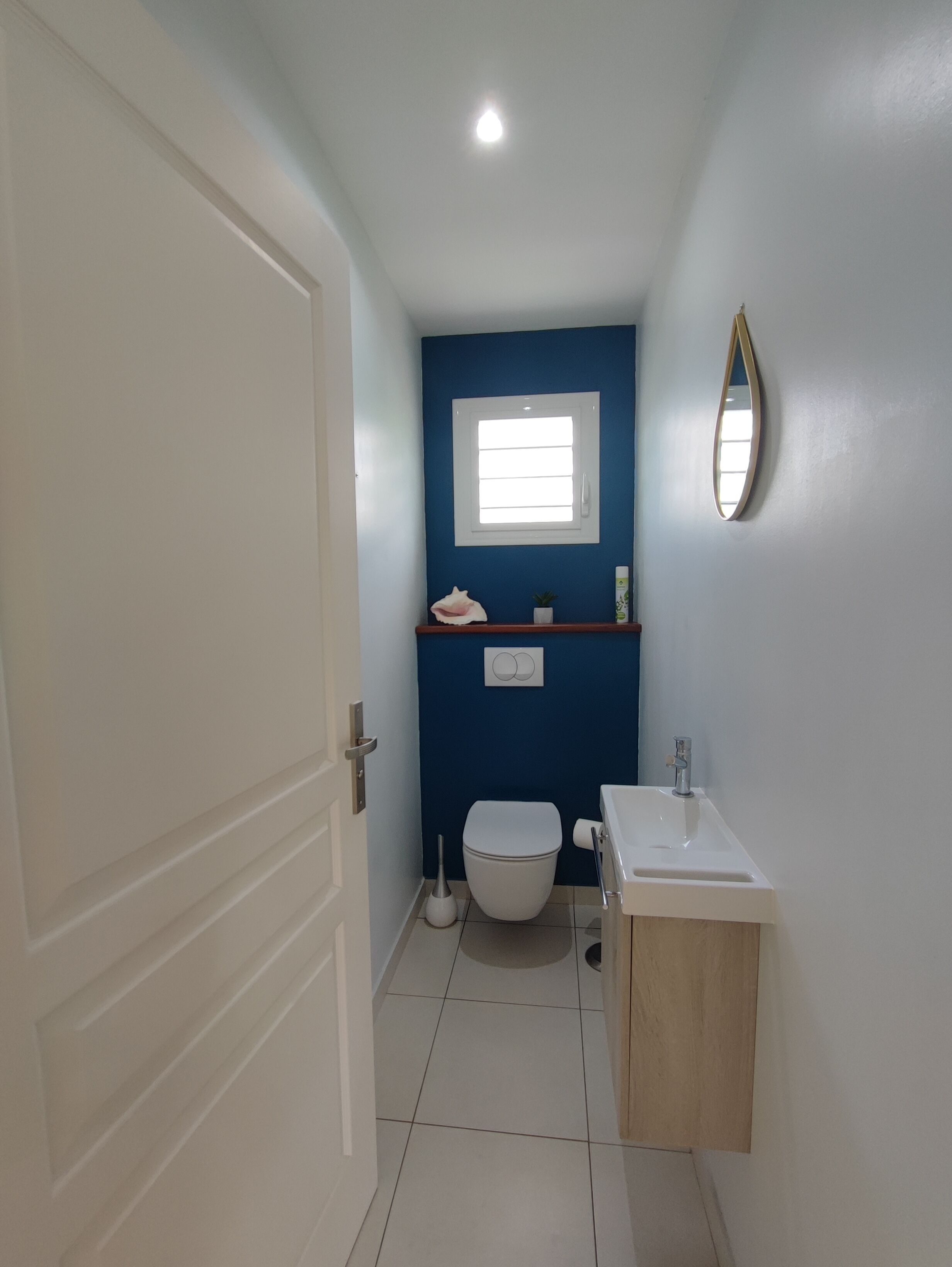 Ein Badezimmer mit Toilette, Waschbecken und einem Fenster.