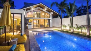 Una casa moderna con piscina, ampie finestre e interni luminosi.