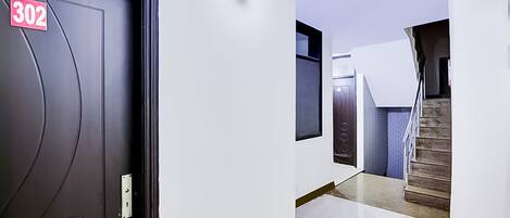 A hallway with a door labeled '302', a staircase, and a modern interior design.