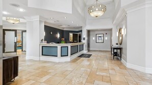 A spacious lobby with a reception desk, a large chandelier, and a tiled floor. - 2BR Executive City Suite With Gym & Pool (Arlington)