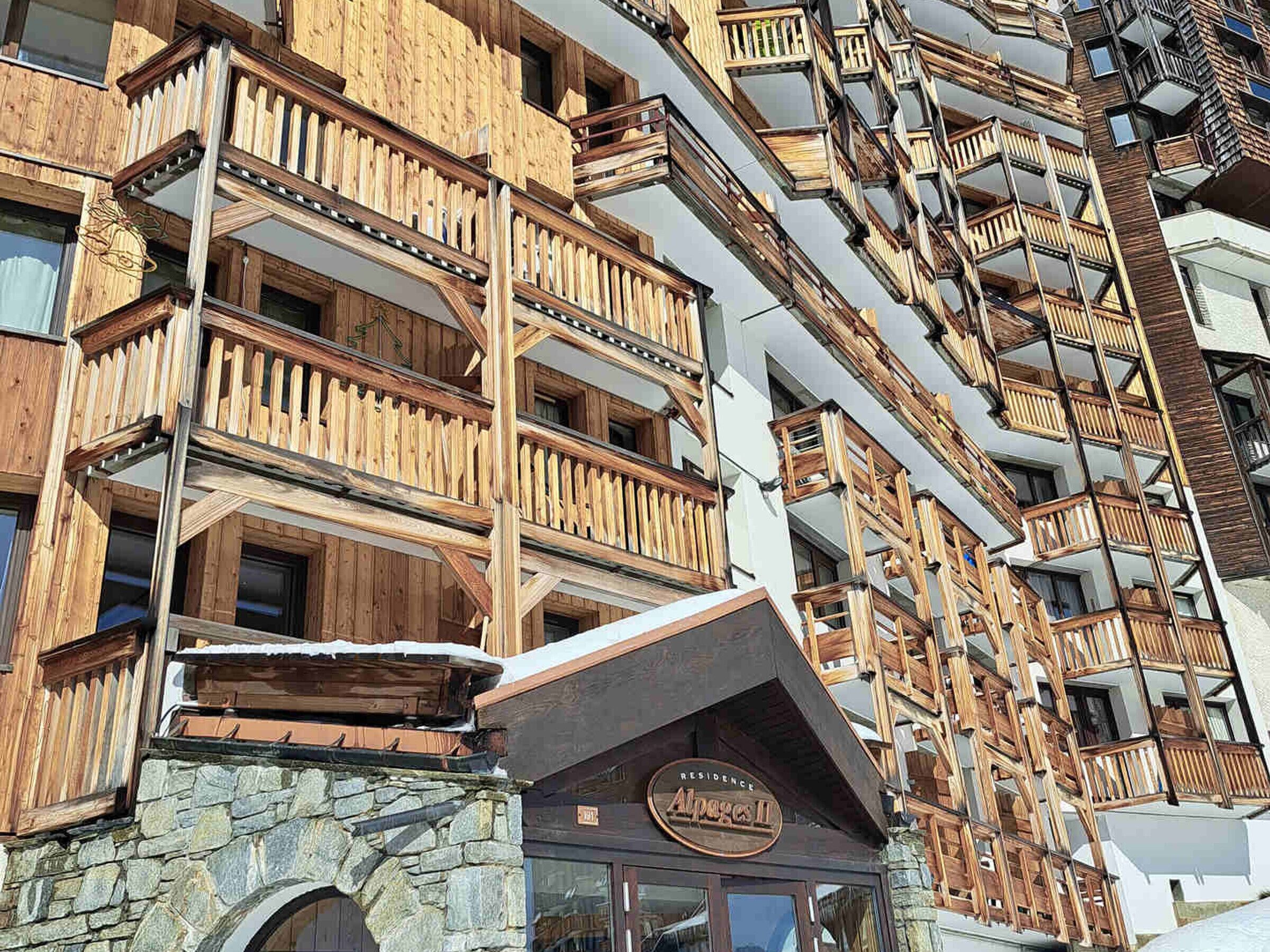 A multi-story building with wooden balconies and a stone facade.