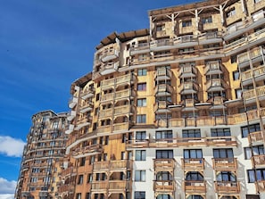 A multi-story building with balconies and large windows.