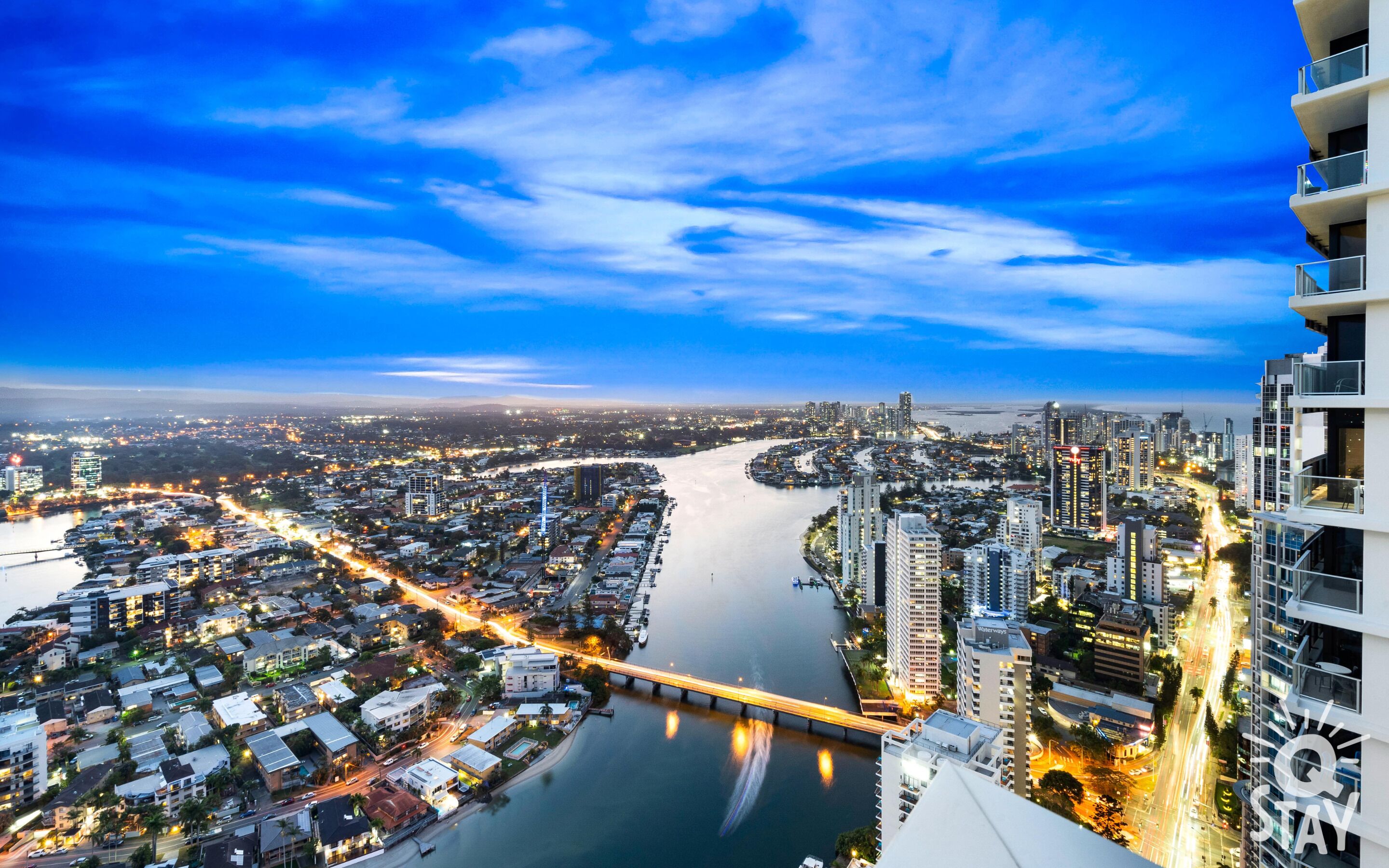 A cityscape with a river, high-rise buildings, and a bridge.