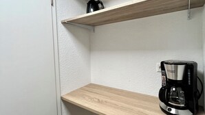A kitchen with wooden shelves and a coffee maker. - 05 Central & quiet with SmartTV (Fellbach)