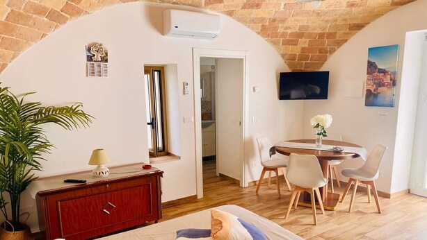 Un dormitorio con cama, escritorio y comedor.