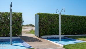 Un área de piscina con dos fuentes de agua, un camino y un seto.