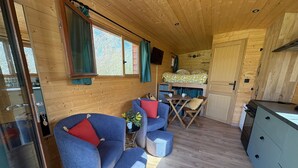 Ein gemütliches Blockhaus-Interieur mit Holzwänden, einer Essecke und einer Küche.