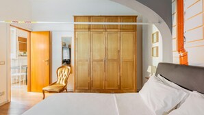 A bedroom with a bed, a wardrobe, a chair, and a desk. - Casa sul Canale di Via Piella by Wonderful Italy (Bologna)