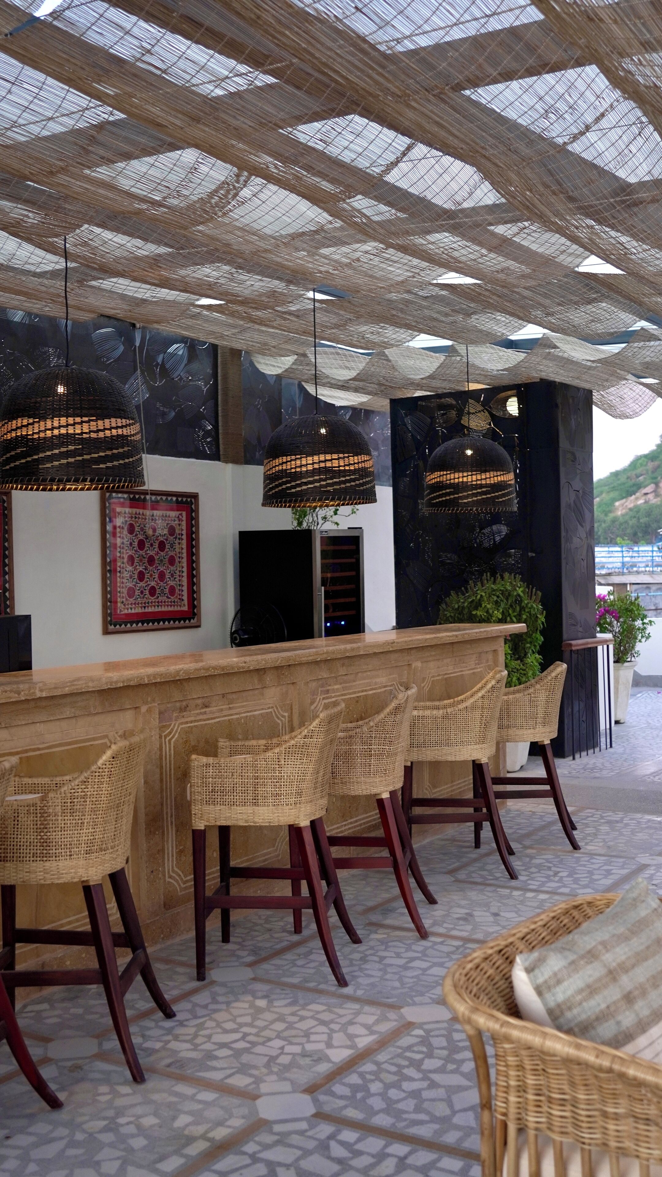 A bar area with wicker chairs and a wooden counter.