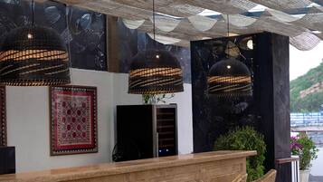 A bar area with wicker chairs and a wooden counter.