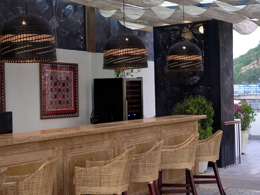 A bar area with wicker chairs and a wooden counter.
