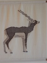 Een wand met een groot, gedetailleerd wandtapijt waarop een bewegende mens figuur afgebeeld is.