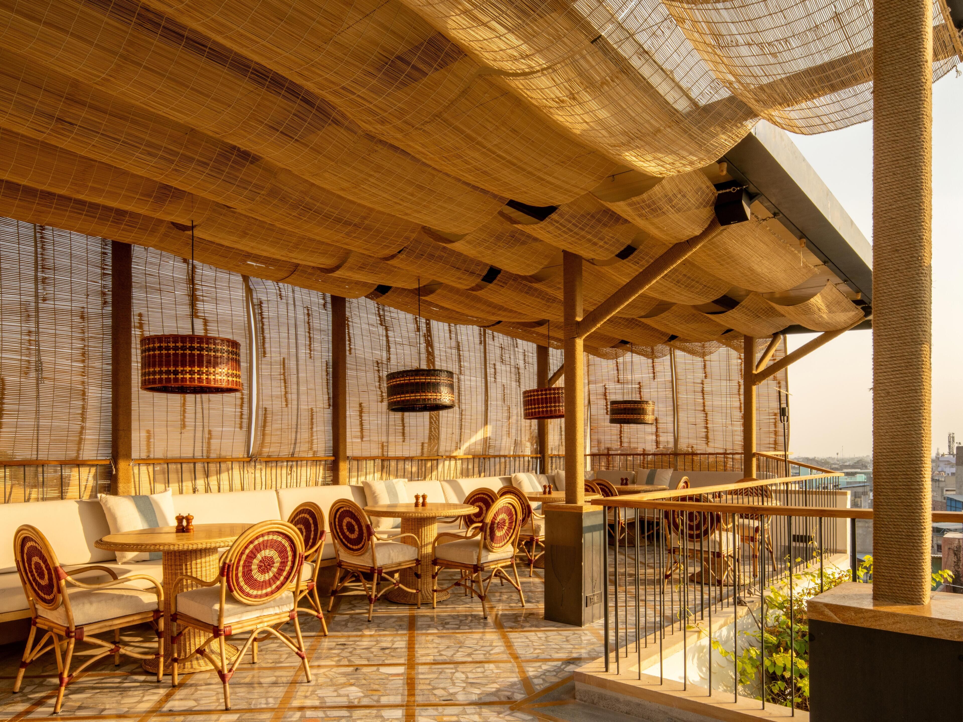 An outdoor seating area with wicker furniture and a view of the city.
