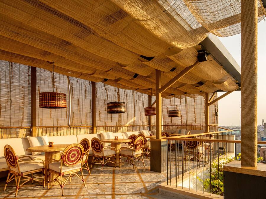 An outdoor seating area with wicker furniture and a view of the city.