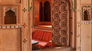 A traditional room with a wooden door, a bench, and a small table.