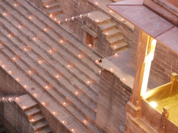 A series of stone steps with candles, leading to a higher level.