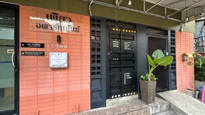 A building with a red brick facade, black doors, and a sign indicating 'F.D. Property'. - Pure Daily - ห้องพักรายวัน Small and Cozy Rooms for Rest (Mueng Samut Prakan,Theparak)