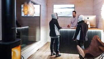 Una habitación con estufa de leña, un ventanal grande y una lámpara moderna.