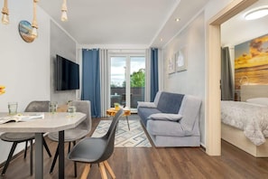 Relax in a cozy seating area with a sofa, flat-screen TV, and a comfortable bed.