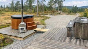 A hot tub with a wooden deck, a wooden bench, and a metal structure. - Nice home in Trysil with house a mountain view (Trysil)