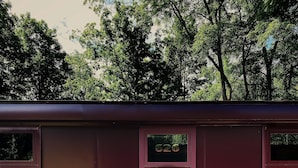 Um vagão de trem parado, com uma porta marcada '2020' e janelas.