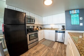 Enjoy cooking in this kitchen with stainless steel appliances, a granite countertop, and a tile backsplash.