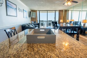 Enjoy ocean views from the large window in this stylish room, featuring a dining area, comfortable seating, and a flat-screen TV.