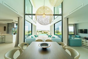Ein modernes Interieur mit Essbereich, großen Fenstern und Blick ins Freie.