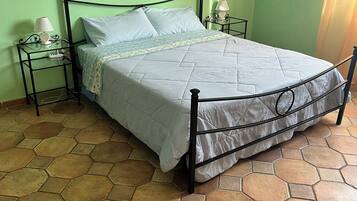 A bed with a metal frame, two bedside tables, and a patterned bedspread.