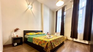 A neatly arranged bedroom with a bed, bedside table, and a wall-mounted light fixture. - Spacious 2-bed Flat  with Balcony, in central Bucharest - Universitate (București)