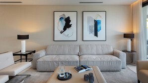 A modern living room with a beige sofa, two side tables with lamps, and two abstract paintings on the wall. - Exceptional 3 bedroom duplex penthouse in Epic Marbella (Marbella)